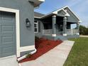 Home exterior displaying a covered front porch with white railings and new landscaping at 14154 Baracoa Ln, Port Charlotte, FL 33981