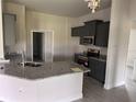 Modern kitchen featuring granite countertops, stainless steel appliances, and gray wood-look tile flooring at 14154 Baracoa Ln, Port Charlotte, FL 33981
