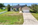 House with a yard, driveway, and white fence at 3021 Palm Dr, Punta Gorda, FL 33950