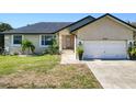 Tan house with a dark roof, white garage door, and landscaping at 3021 Palm Dr, Punta Gorda, FL 33950