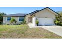 Tan house with a dark roof, white garage door, and landscaping at 3021 Palm Dr, Punta Gorda, FL 33950