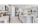 Open concept kitchen boasting white cabinets, a large island, and stainless steel appliances at 5131 Schubert Trl, North Port, FL 34287