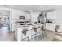 Bright kitchen featuring white cabinets, an island, and stainless steel appliances at 5131 Schubert Trl, North Port, FL 34287