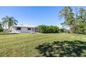Spacious backyard with lush grass and partial view of the house at 3014 Guadalupe Dr, Punta Gorda, FL 33950