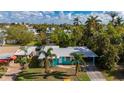 Charming, turquoise single-Gathering home featuring a carport and palm trees in a lush, tropical neighborhood at 350 Gill St, Punta Gorda, FL 33950