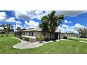 Single-story home with mature landscaping and a large grassy yard at 112 Sunnyside Nw St, Port Charlotte, FL 33952
