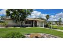 House with carport, mature landscaping, and a large grassy yard at 112 Sunnyside Nw St, Port Charlotte, FL 33952