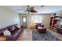 Spacious living room with hardwood floors, leather furniture, and ceiling fan at 112 Sunnyside Nw St, Port Charlotte, FL 33952