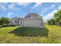 Attached garage with a gray door and windows at 15871 Huffmaster Rd, North Fort Myers, FL 33917