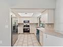 Galley kitchen with stainless steel appliances and light cabinets at 21047 Baffin Ave, Port Charlotte, FL 33954
