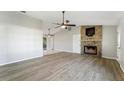 Bright living room featuring a stone fireplace and wood-look floors at 21047 Baffin Ave, Port Charlotte, FL 33954