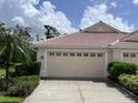 Tan house with a two-car garage and manicured landscaping at 4371 Whispering Oaks Dr., North Port, FL 34287