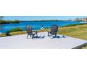 Waterfront deck featuring two chairs and a table for relaxing and enjoying water views at 5117 Collingswood Blvd, Port Charlotte, FL 33948