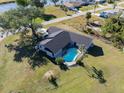 Aerial view of home with in-ground pool, lush lawn, and well-maintained landscaping near a waterway at 7359 Van Lake Dr, Englewood, FL 34224