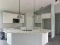 Modern kitchen features white cabinets, a large island, and stainless steel appliances at 13541 Jeronimo Ln, Port Charlotte, FL 33981
