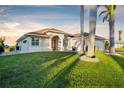 Light beige house with a double door entry and palm trees at 15258 Addax Ave, Port Charlotte, FL 33981