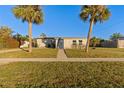 Charming single story home with a landscaped lawn and palm trees at 3432 Easy St, Port Charlotte, FL 33952