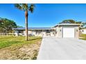 Single-story home with metal roof, light gray siding, and a two-car garage at 824 E 6Th St, Englewood, FL 34223