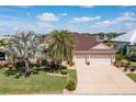 Single story home with a tile roof, two car garage, and mature landscaping at 128 Great Isaac Ct, Punta Gorda, FL 33950