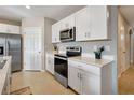 Well-equipped kitchen featuring white cabinets, stainless steel appliances, and ample counter space at 16031 Quinta Dr, Punta Gorda, FL 33955