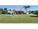 Single-story home exterior with a well-manicured lawn and palm trees at 27415 Tierra Del Fuego Cir, Punta Gorda, FL 33983