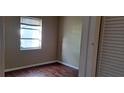 Simple bedroom with wood flooring and a window with blinds at 2813 Starlite Ln, Port Charlotte, FL 33952