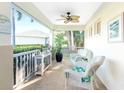 Relaxing screened porch with wicker chairs and ceiling fan at 17513 Pomegrante Way, Punta Gorda, FL 33955