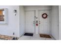Apartment entrance featuring a festive wreath, secure doors, and visible unit numbers at 26485 Rampart Blvd # E7, Punta Gorda, FL 33983