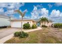 House exterior with attached garage and lush landscaping at 3220 Peace River Dr, Punta Gorda, FL 33983