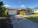 Tan house with a white garage door and landscaping at 4525 Church St, Punta Gorda, FL 33980