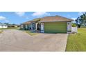 House exterior showcasing a green garage door and landscaping at 98 Seasons Dr, Punta Gorda, FL 33983