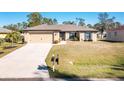 Single-story home with attached garage and driveway at 2696 Mather Ln, North Port, FL 34286