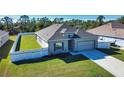 Well-maintained home with a two-car garage, gray siding, white fence, and manicured lawn and landscaping at 3393 Kacher Rd, North Port, FL 34288