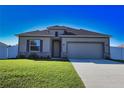 Beautiful single-story home with a well-manicured lawn, two-car garage, and stone accents near the entryway at 3393 Kacher Rd, North Port, FL 34288