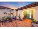 Brick patio with seating area, lush landscaping, and teal front door at 3819 Turtle Dove Blvd, Punta Gorda, FL 33950