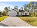 House exterior featuring a paver driveway and grassy lawn at 14059 Gailwood Ave, Port Charlotte, FL 33953