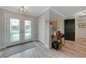 Bright and airy foyer with hardwood floors, a console table, and double doors at 2701 Bay Ct, Punta Gorda, FL 33950