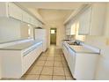 Efficient kitchen with white cabinets and tiled floors at 6222 Berkeley St, Englewood, FL 34224