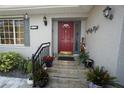 Inviting entryway with a red front door, landscaping, and a gray exterior at 726 Macedonia Dr, Punta Gorda, FL 33950