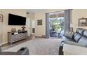 Comfortable living room featuring a sliding glass door to screened patio and backyard pool at 1205 Bartlett Ave, North Port, FL 34288