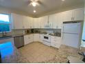 Spacious kitchen with white shaker cabinets, granite counters, and stainless steel appliances at 12090 Malaga Ave, North Port, FL 34287