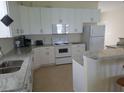 Bright kitchen featuring white cabinetry, granite countertops, and white appliances at 12090 Malaga Ave, North Port, FL 34287