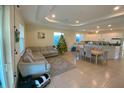 Open concept living area with a sectional sofa, dining table, and decorated Christmas tree at 12090 Malaga Ave, North Port, FL 34287
