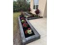 Charming front yard features a flower bed with multi-colored flowers and lush plants at 18043 Avonsdale Cir, Port Charlotte, FL 33948