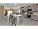 Modern kitchen with gray cabinets, stainless steel appliances, and an island at 18043 Avonsdale Cir, Port Charlotte, FL 33948