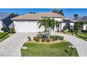 Charming single-story home featuring a brick driveway and landscaping including mature palm trees at 5541 Almar Dr, Punta Gorda, FL 33950