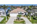 Beautiful waterfront home featuring a brick driveway, a two-car garage, and well-manicured landscaping at 5541 Almar Dr, Punta Gorda, FL 33950