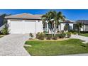 Single Gathering home with a paver driveway, two-car garage and mature landscaping at 5541 Almar Dr, Punta Gorda, FL 33950