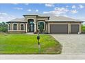 Two-story home with three-car garage and manicured lawn at 8265 Dafoe St, Port Charlotte, FL 33981