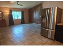 Open concept kitchen and living area with tile floors, natural light, and stainless steel refrigerator at 11332 8Th Ave, Punta Gorda, FL 33955